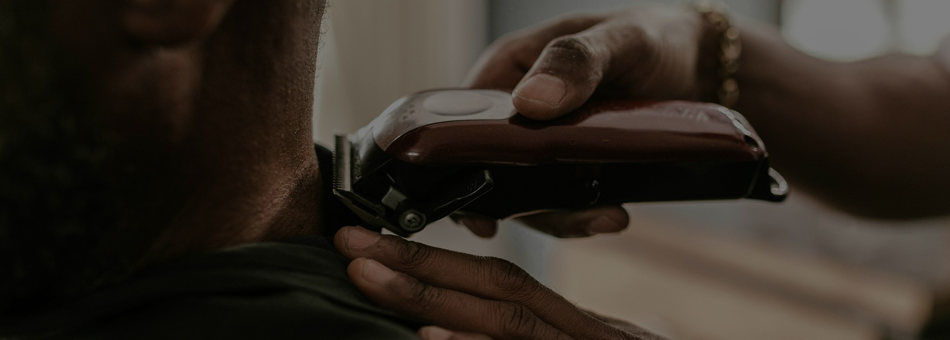 Barber using clippers on the back of a client's neck