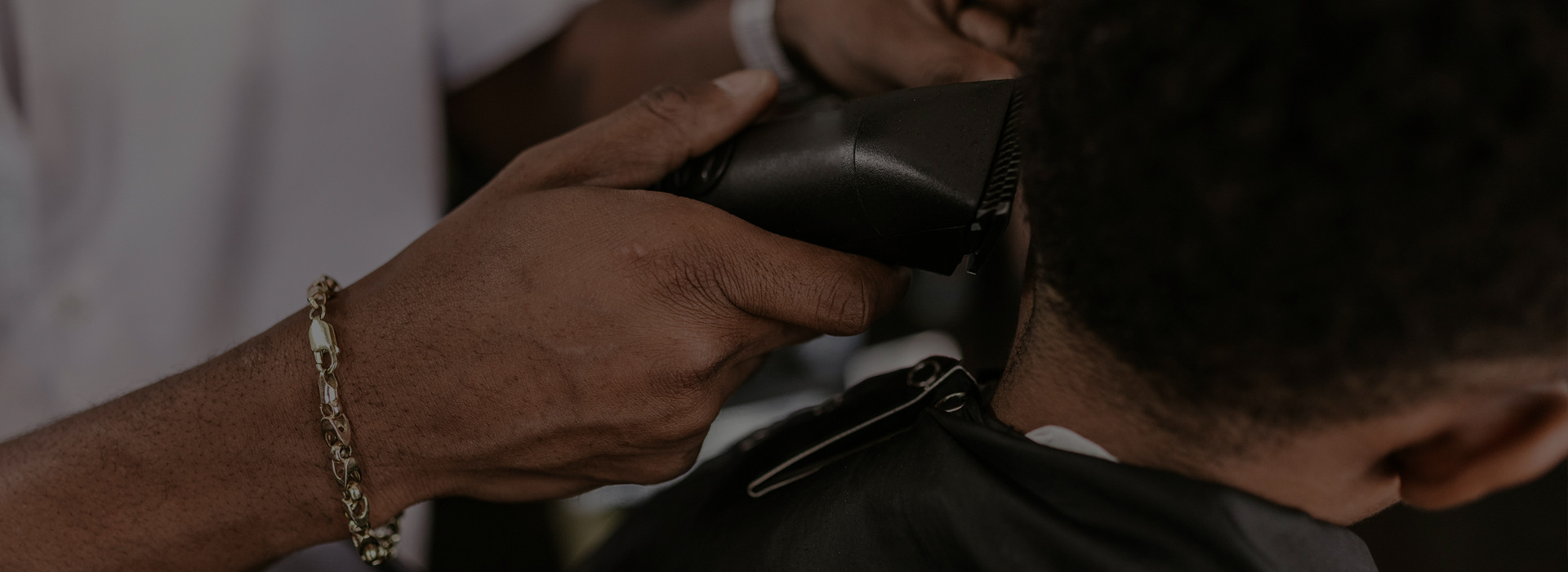 Barber cutting a client's hair with clippers