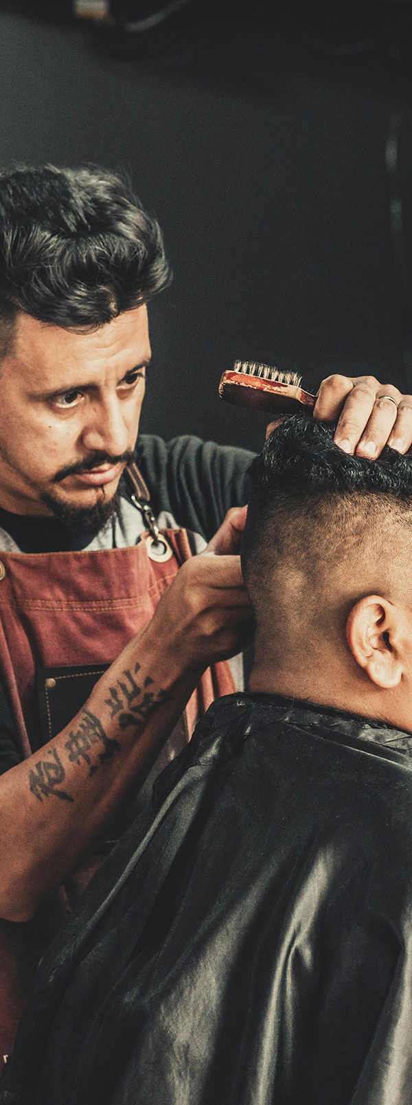 Tall crop: barber in a red apron with the pole mural